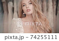 Portrait of glamorous bride model standing in salon with wedding dresses. Closeup of elegant woman 74255111