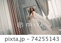 Bride woman in wedding dress. Charming model pose in flying gown. Flowing fabric of new collection 74255143