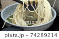 Cooking spaghetti with green sauce in a stone pan - montage 74289214