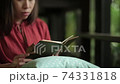 Young woman reading a book in cafe. 74331818