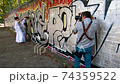 Professional wedding photographer taking portraits of handsome and elegant groom near the silver graffiti on the wall 74359522