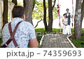 Professional wedding photographer taking pictures couple of newlyweds on a rope swing 74359693
