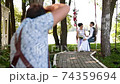 Professional wedding photographer taking pictures couple of newlyweds on a rope swing 74359694