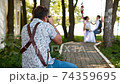 Professional wedding photographer taking pictures couple of newlyweds on a rope swing 74359695