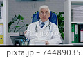 Adult male physician therapist with glasses communicates by video link. Communication with the patient remotely, consultation with a medical specialist. 74489035