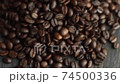 Roasted arabica coffee beans scattered on a wooden table. Fresh coffee beans. Espresso, americano, doppio, cappuccino, latte. Robusta. Selective focus. 74500336