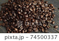 Roasted arabica coffee beans scattered on a wooden table. Fresh coffee beans. Espresso, americano, doppio, cappuccino, latte. Robusta. Selective focus. 74500337