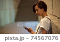 Woman using a smartphone 74567076