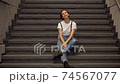 Woman taking a break on the stairs 74567077