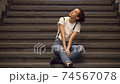 Woman taking a break on the stairs 74567078