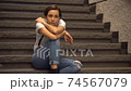 Woman taking a break on the stairs 74567079