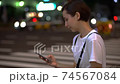 Women using smartphones in the crowd (night, cityscape, city) 74567084