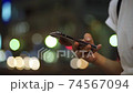 Body parts at hand for women who use smartphones in the crowd (night, cityscape, city) 74567094