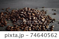 Roasted arabica coffee beans scattered on a wooden table. Fresh coffee beans. Espresso, americano, doppio, cappuccino, latte. Robusta. Selective focus. 74640562