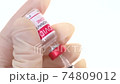 Closeup doctor fills the syringe with the coronavirus vaccine from the ampoule. Concept of treatment of coronavirus infection, COVID-19 vaccination. 4k 74809012