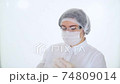 Doctor in protective mask and cap opens the package of the insulin syringe to give the injection. Concept of treatment insulin-dependent diabetes mellitus or COVID-19 74809014