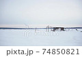 Abandoned building on the background of a snowy field. 74850821