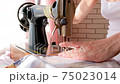 a young girl sews dresses on an old retro sewing machine. 75023014