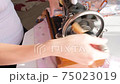 girl sews on an old retro hand sewing machine 75023019