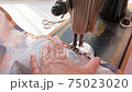 girl sews on an old retro hand sewing machine 75023020