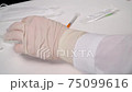 Closeup doctor fills the syringe with the coronavirus vaccine from the ampoule. Concept of treatment of coronavirus infection, COVID-19 vaccination 75099616