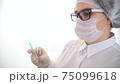 Young caucasian female doctor holds a syringe and a bottle of coronavirus vaccine. Concept of treatment of coronavirus infection, COVID-19 vaccination 75099618