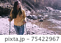 Young woman during a Nordic walking hiking on board a river in the nature Young woman during a Nordic walking hiking on board a river in the nature 75422967