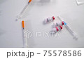top view vaccine bottles for the treatment of coronavirus infection roll on a wooden white table 75578586