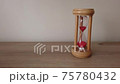 Hourglass countdown sand falls in a sandglass on wood desk. Passing time concept. 75780432