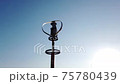 Vertical axis wind turbine utilize renewable wind energy while spinning against blue sky. 75780439