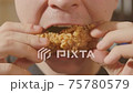 Young man eating chicken wing fast food close up. 75780579