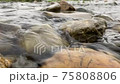 A close-up shot of the surface of the water flowing over the rocks 75808806