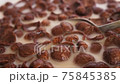 eating chocolate cereals with spoon, morning breakfast close-up 75845385