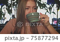 Tracking shot of girl drinking some hot bewerade in cafeteria. 75877294