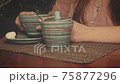 Lady is drinking cappuccino. Coffee served in front of her in stripped ceramic cup. 75877296