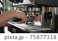 Barista cleaning the coffee machine 75877318