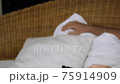 Close-up of a hand with TV remote controller switching TV channels. Slow motion 75914909