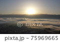 A city surrounded by the rising sun and morning mist from the Alps 75969665