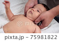 Male doctor's hands massage the baby. A child who is being massaged is lying on the couch. The first massage in a child's life. Close up 75981822