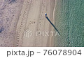 ビーチに散歩しに来た女性の空撮 76078904