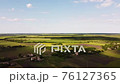 Aerial view of endless lush pastures and farmlands. Beautiful countryside with emerald green fields and meadows. Rural landscape on sunset. 76127365