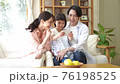 A young family watching videos on a smartphone 76198525