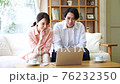 Young couple looking at a computer in the living room 76232350