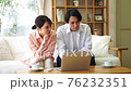 Young couple looking at a computer in the living room 76232351