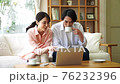 Young couple looking at a computer in the living room 76232396