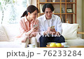 Young couple looking at a smartphone in the living room 76233284