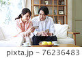 Young couple looking at a smartphone in the living room 76236483