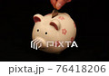put coin into piggy bank. 76418206