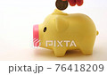 putting coins in a piggy bank 76418209