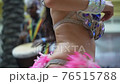 Celebration of Brazilian carnival. Beautiful girl in colorful festive costume decorated with rhinestones and feathers are dancing samba at street 76515788
